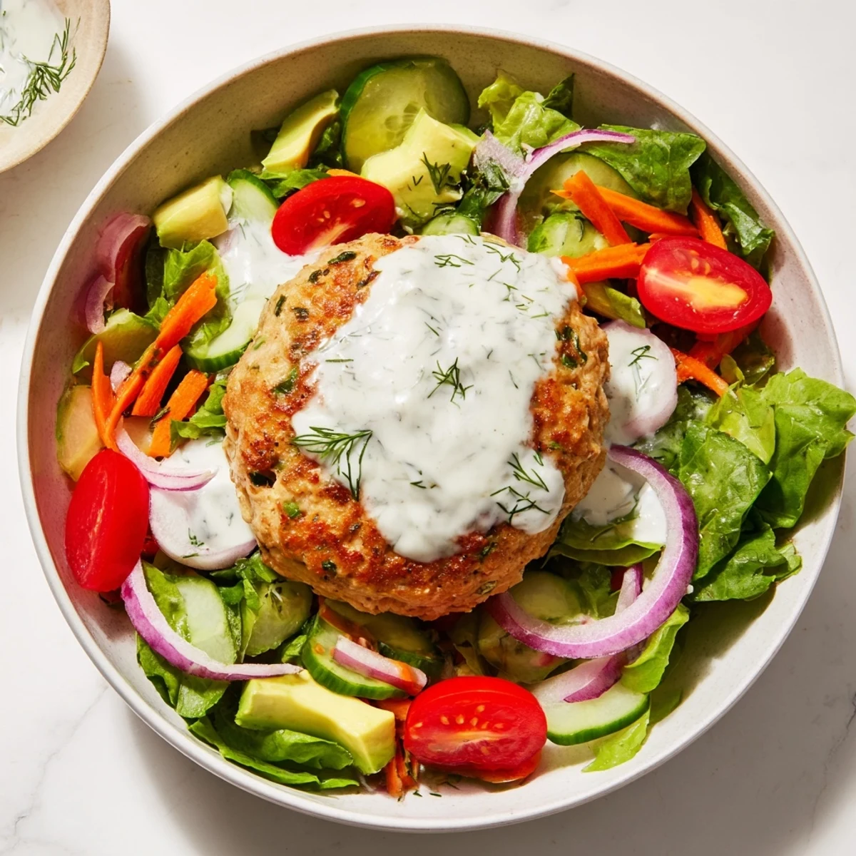 Juicy turkey burger salad bowl with crisp greens, avocado, and creamy dill yogurt dressing.