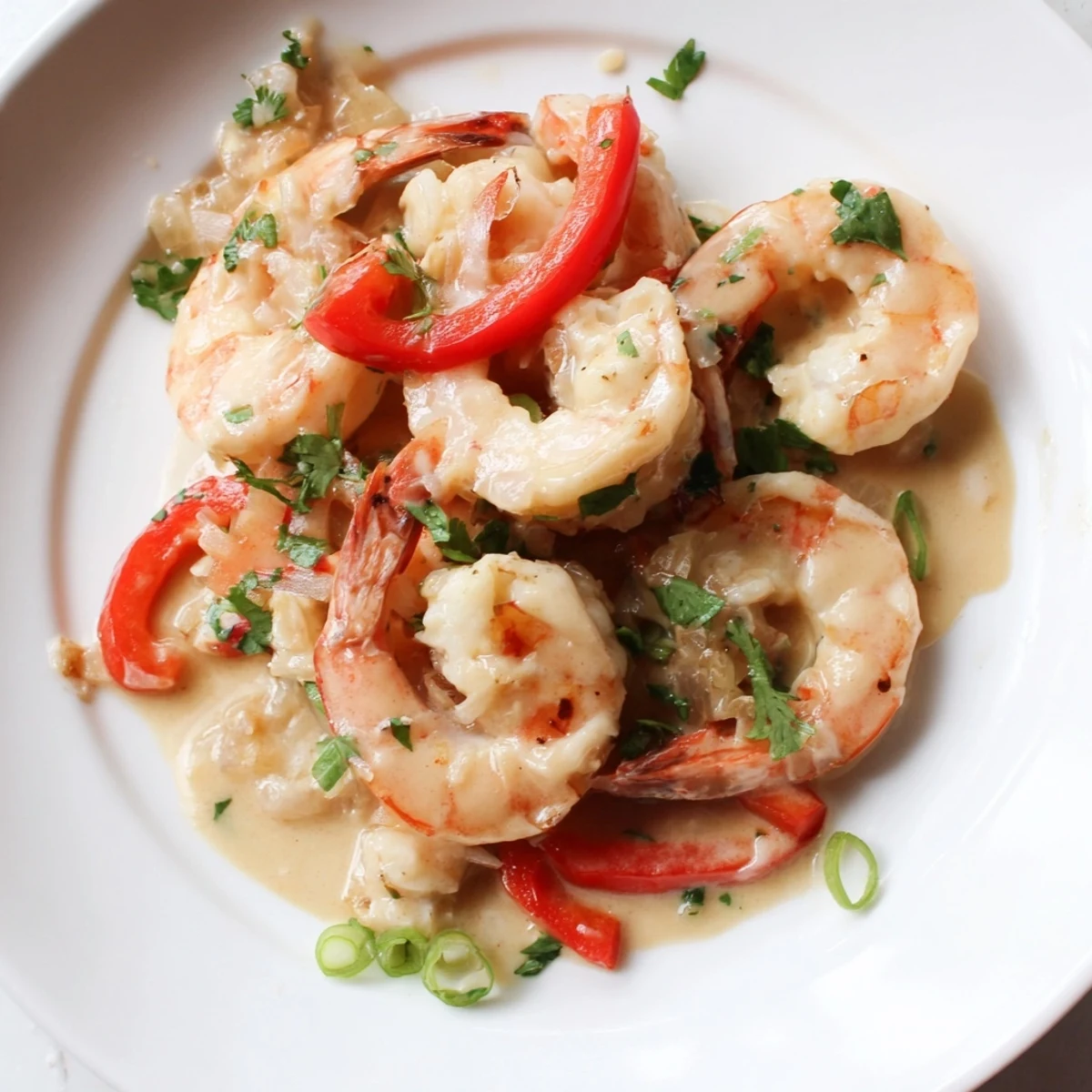 Warm skillet of Garlic Shrimp in Coconut Milk with aromatic garlic and green onions, perfect for a gluten-free main dish.