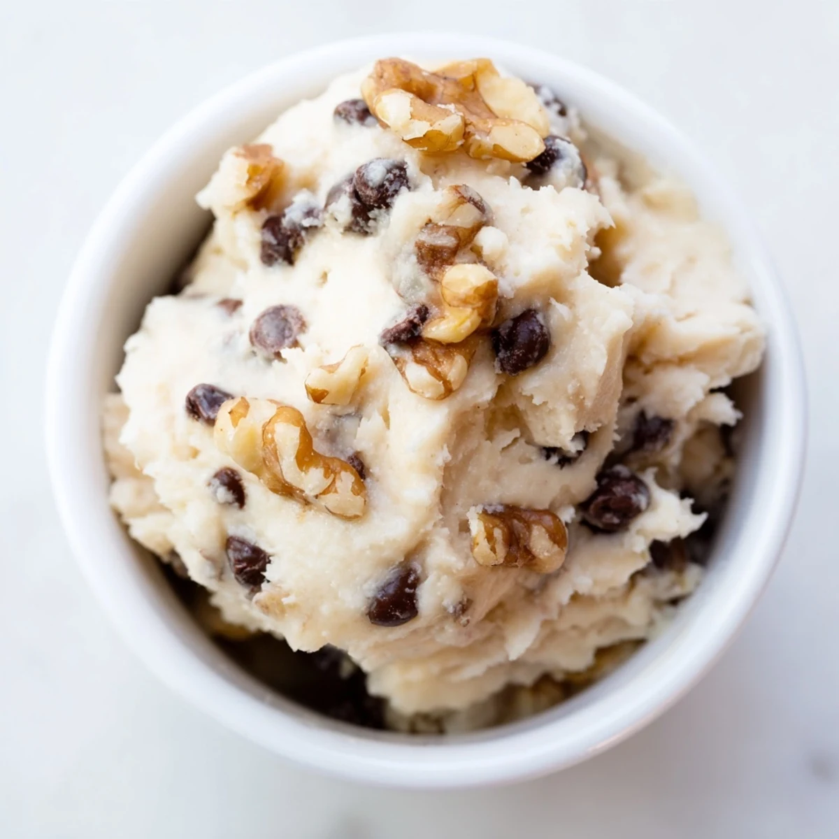 Close-up of Guilt Free Greek Yogurt Cookie Dough with a swirl of peanut butter and glistening mini chocolate chips.