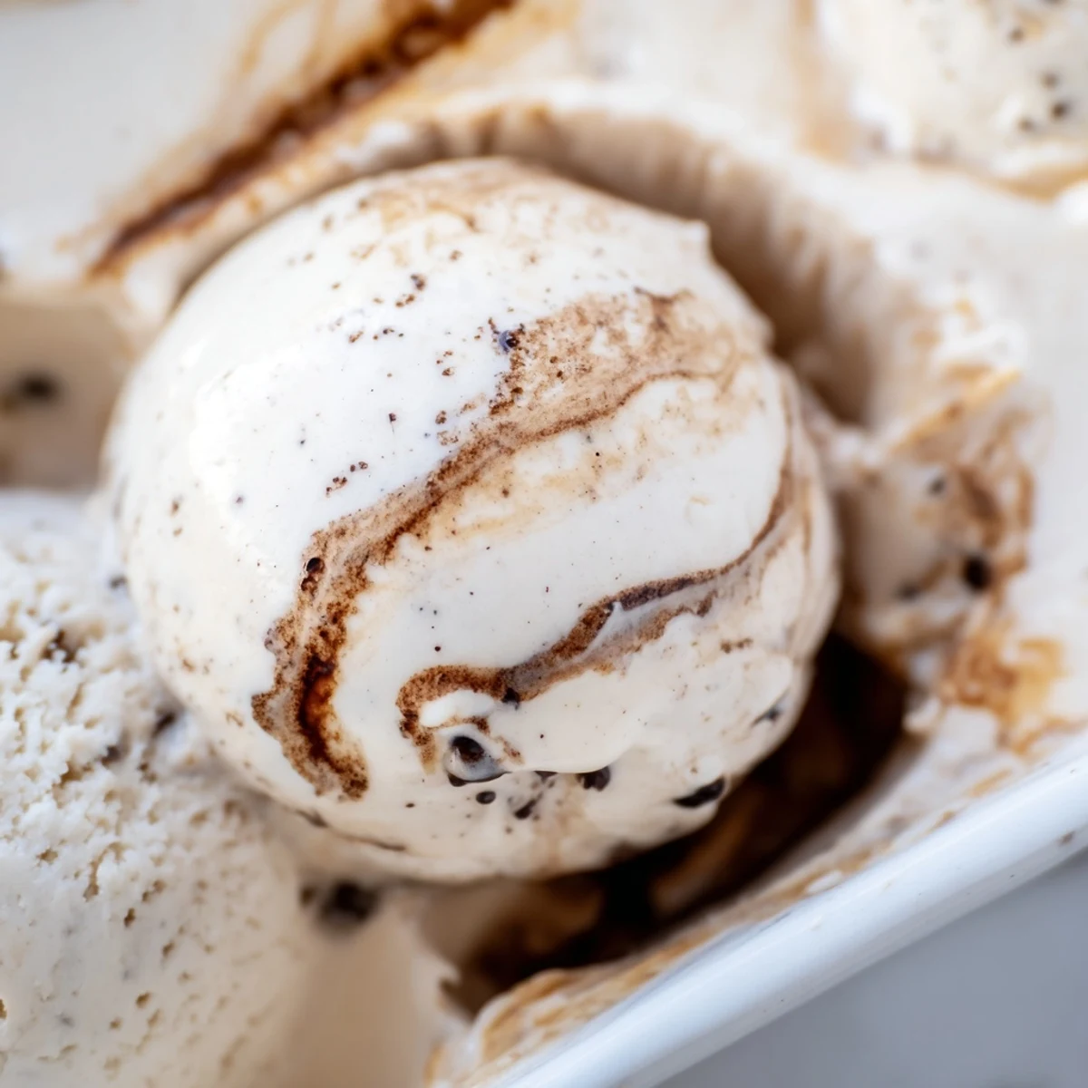 Creamy Vietnamese Coffee Ice Cream in a rustic ceramic bowl with a drizzle of sweetened condensed milk.