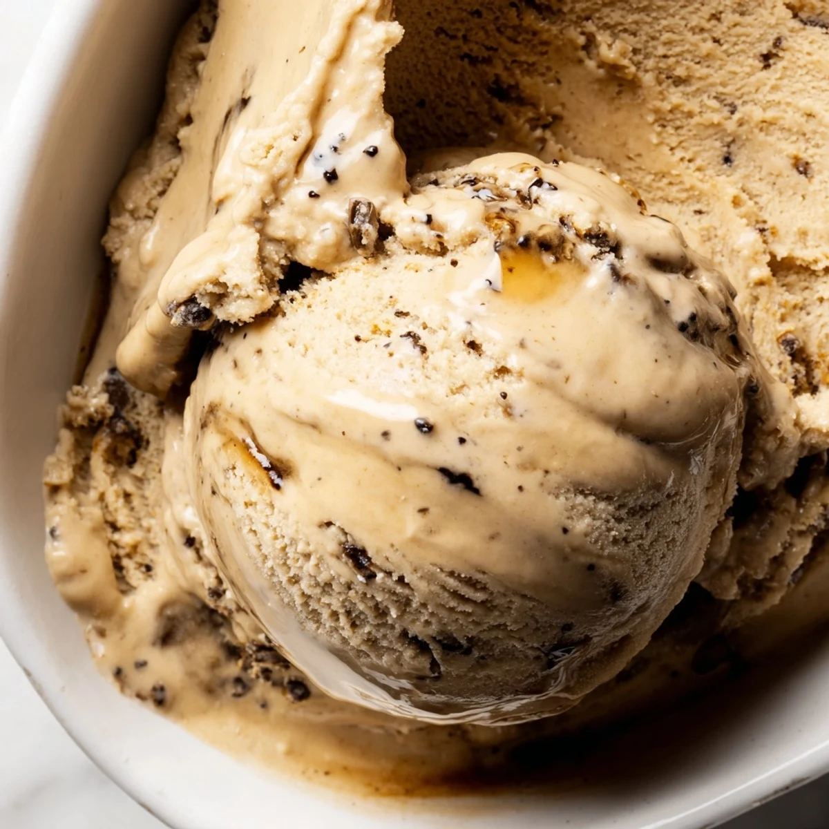 Vietnamese Coffee Ice Cream scoops sit next to a steaming mug of espresso for an affogato.