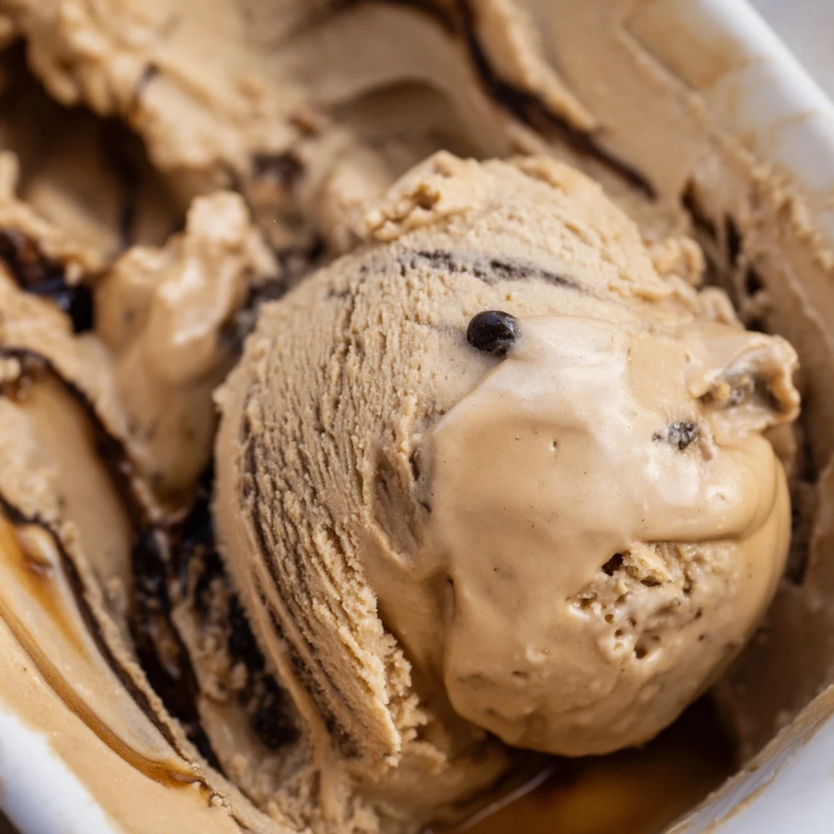A close-up of homemade Vietnamese Coffee Ice Cream with visible coffee flecks and a spoon ready.