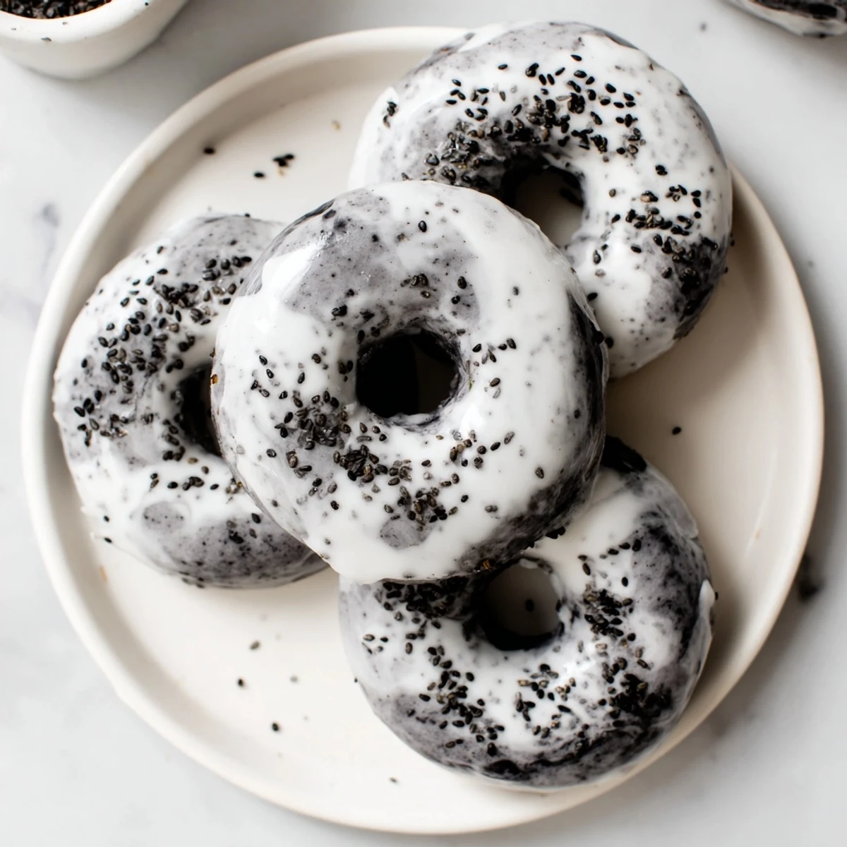 A close-up of Black Sesame Mochi Donuts showing their crackly glaze and chewy mochi texture. 