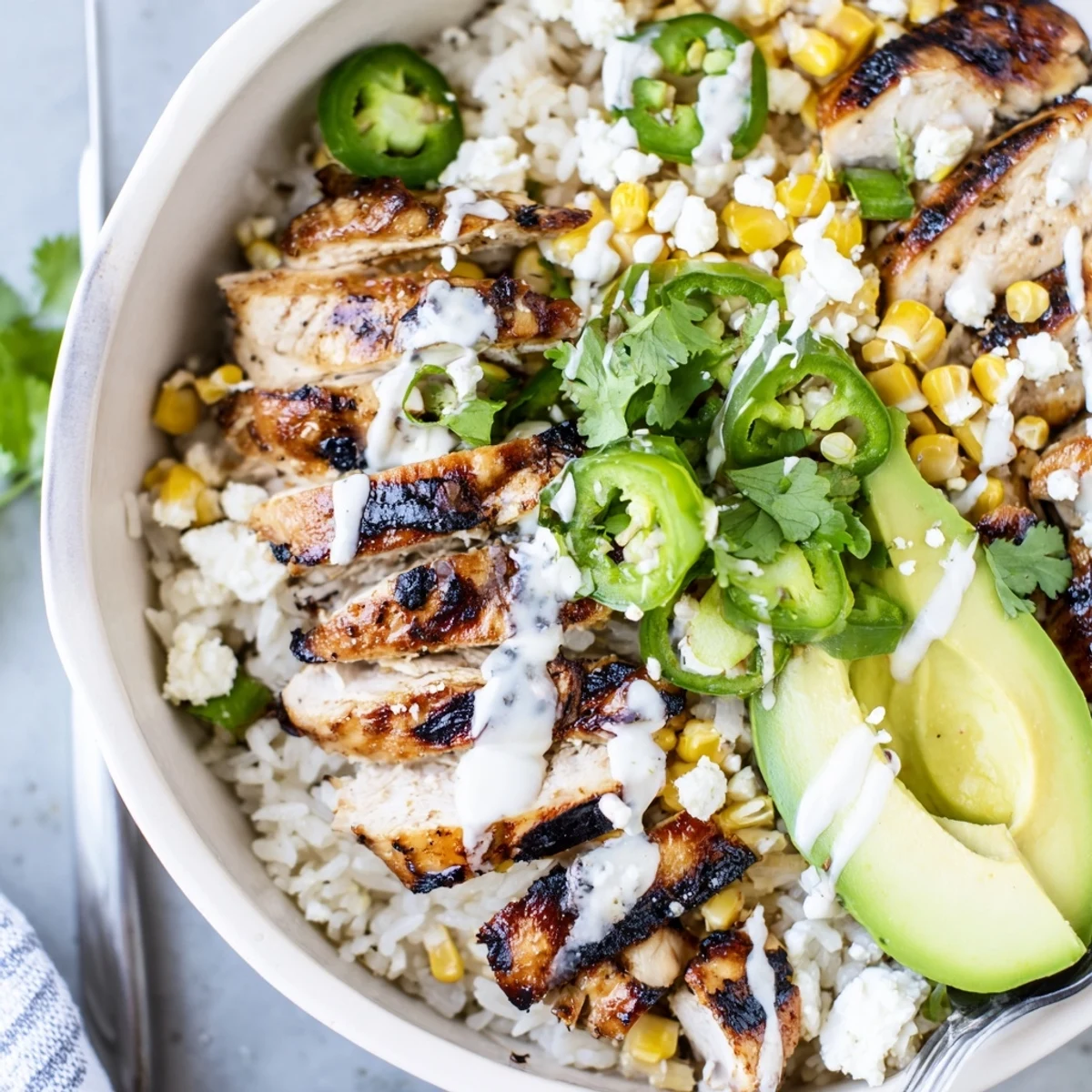 Vibrant Street Corn Chicken Bowl with avocado slices, cotija cheese, and cilantro.