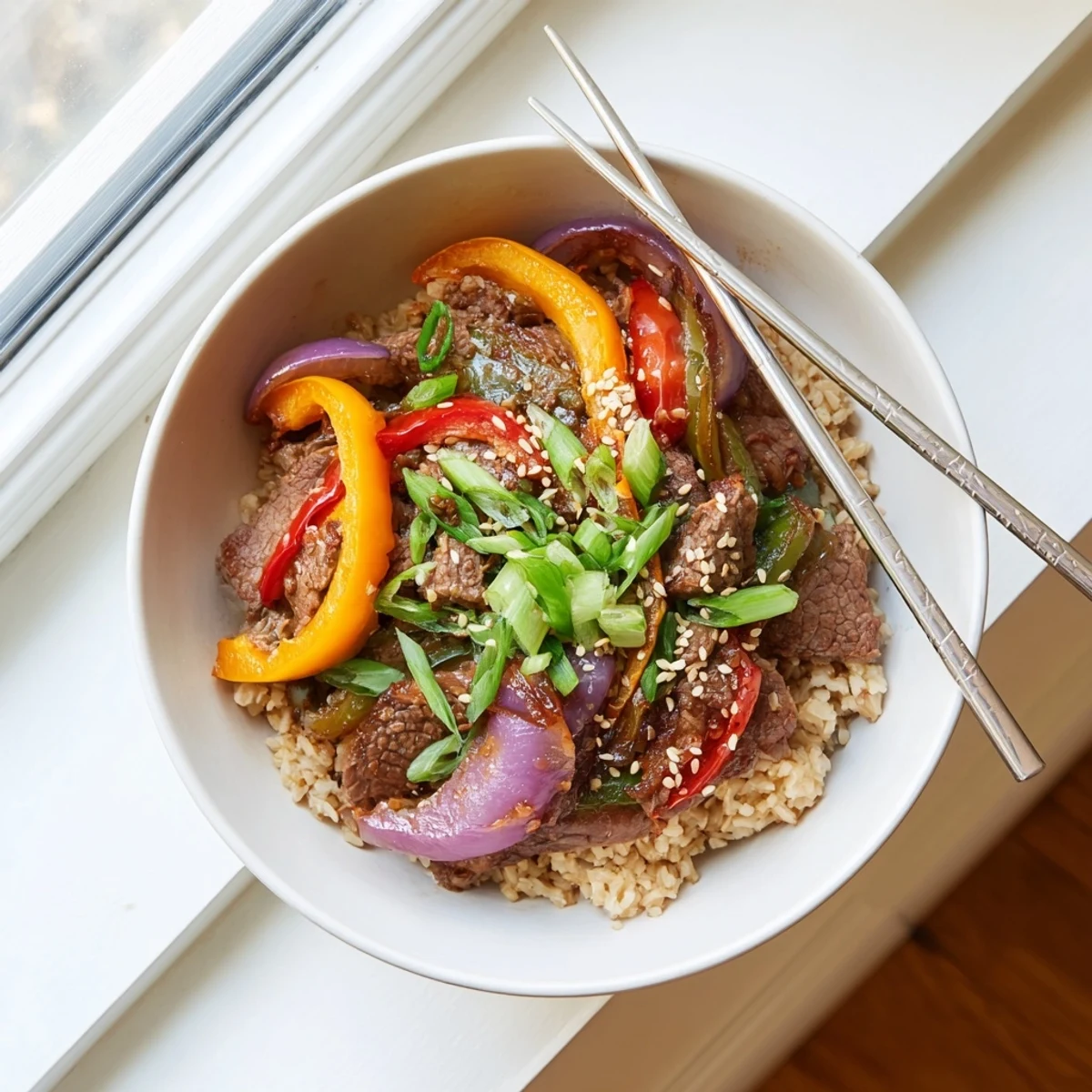 Vibrant Healthy Beef and Pepper Rice Bowl topped with colorful bell peppers and savory garlic-ginger sauce