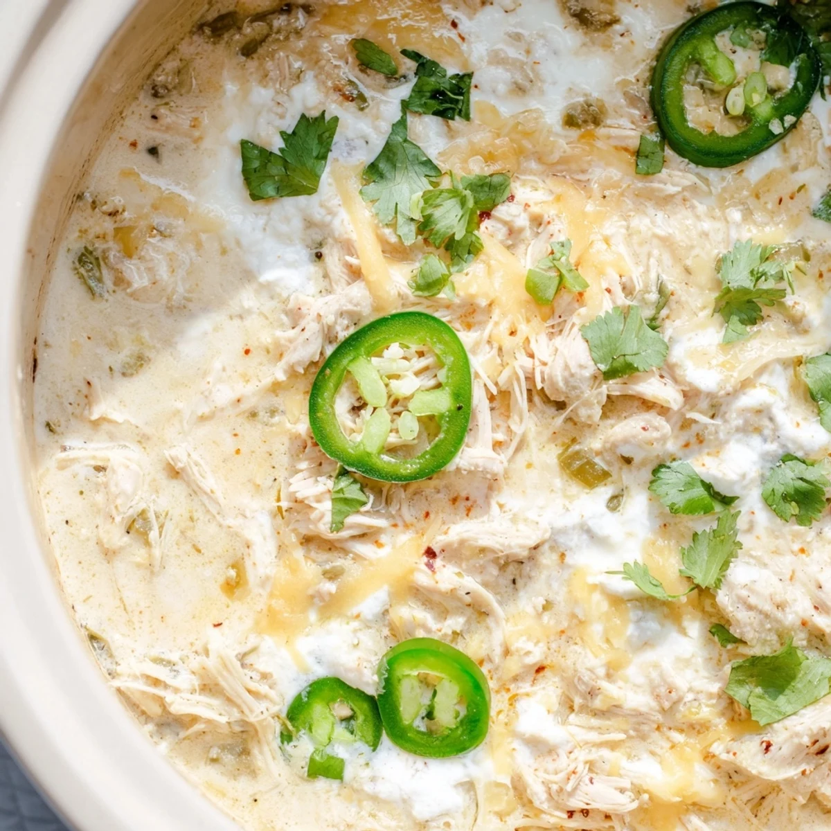 Hearty low-carb white chicken chili featuring tender chunks of chicken in a rich, spicy cream broth