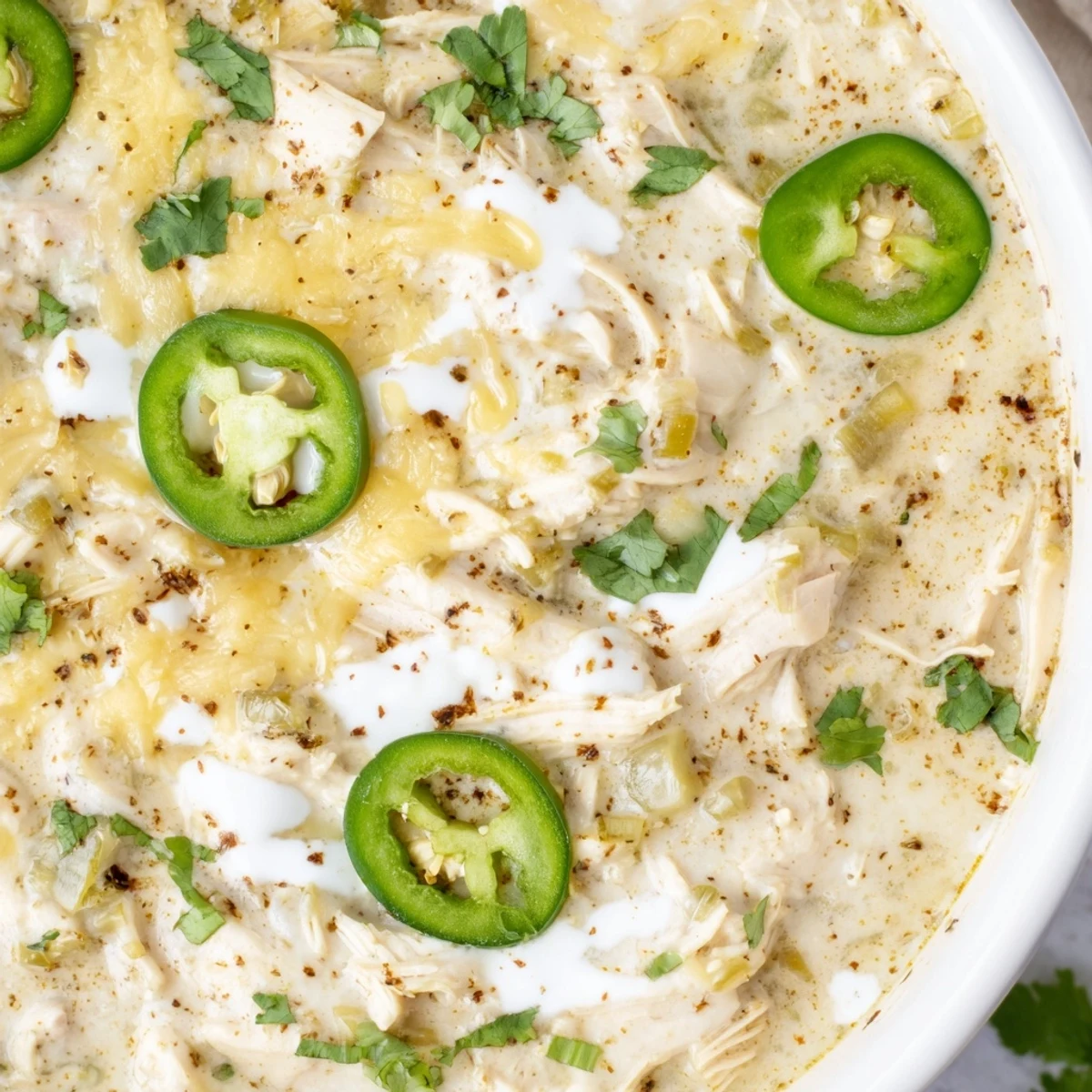 Steaming bowl of simple keto white chicken chili topped with fresh cilantro and lime wedges