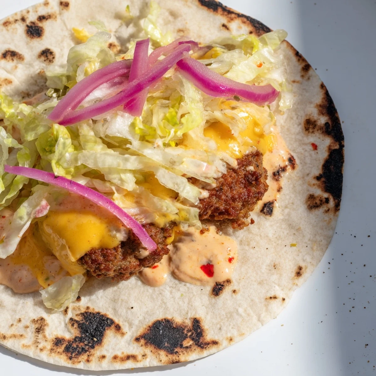 Golden crispy smash burger tacos loaded with melted cheese and fresh vegetable toppings