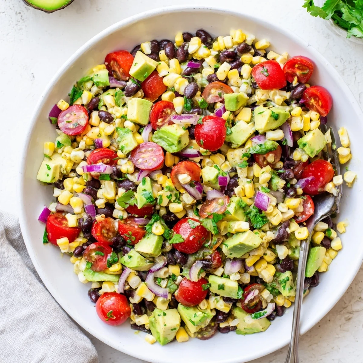 Vibrant summer corn and black bean salad plated with red bell pepper and cilantro garnish