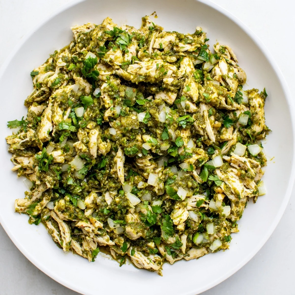 Tender shredded chicken simmered in zesty salsa verde sauce for vibrant Taco Tuesdays