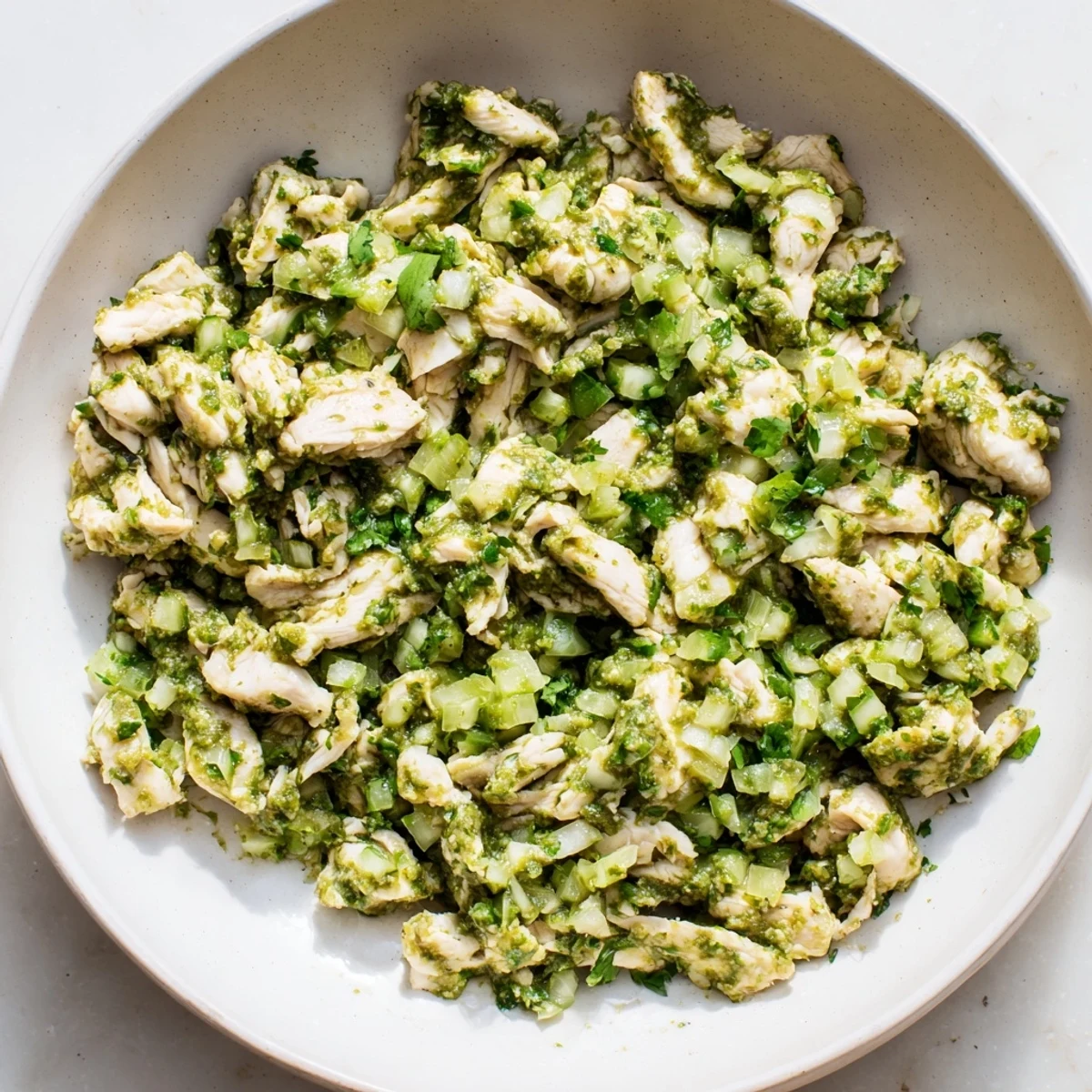 Salsa verde chicken dish garnished with fresh cilantro and creamy avocado slices