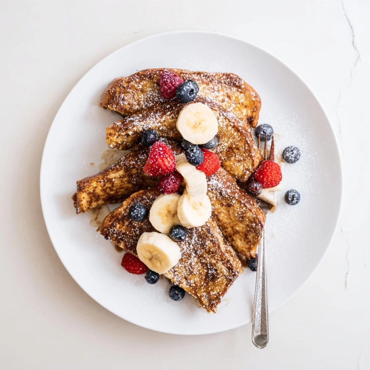 Dairy-free French toast stacked high topped with maple syrup and sliced bananas