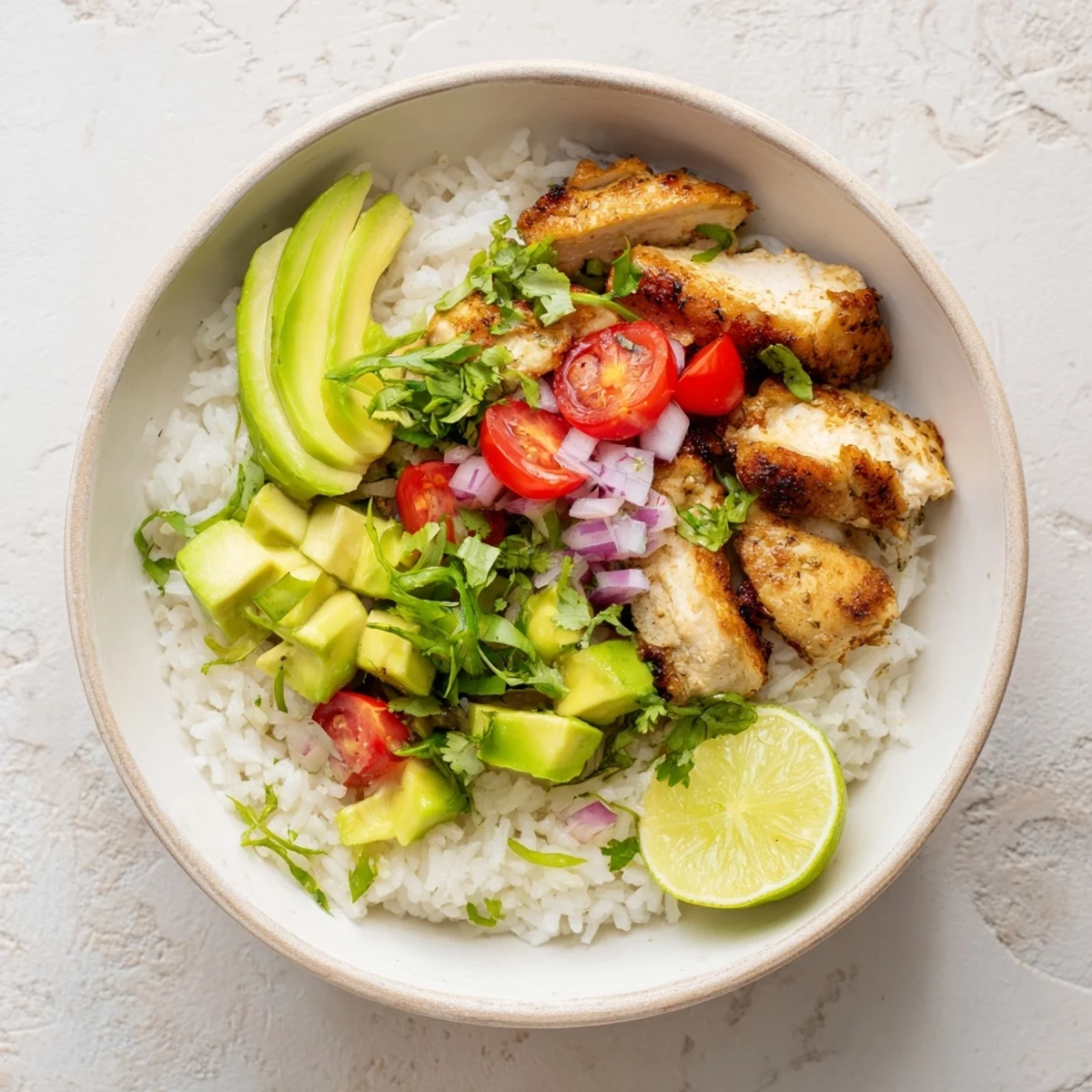 Colorful honey lime chicken avocado rice bowl with tender sliced chicken and fresh toppings