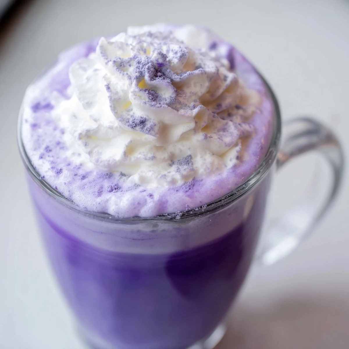 Iced ube latte showcasing swirling purple layers of yam, milk, and coffee