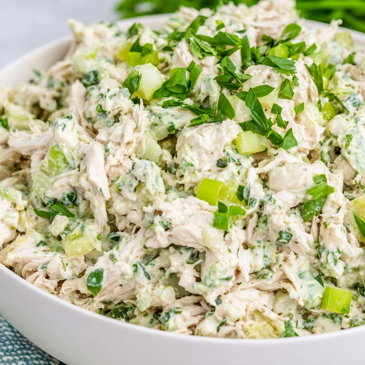 Vibrant Green Goddess Chicken Salad Dip featuring tender chicken and chopped herbs atop cucumber slices