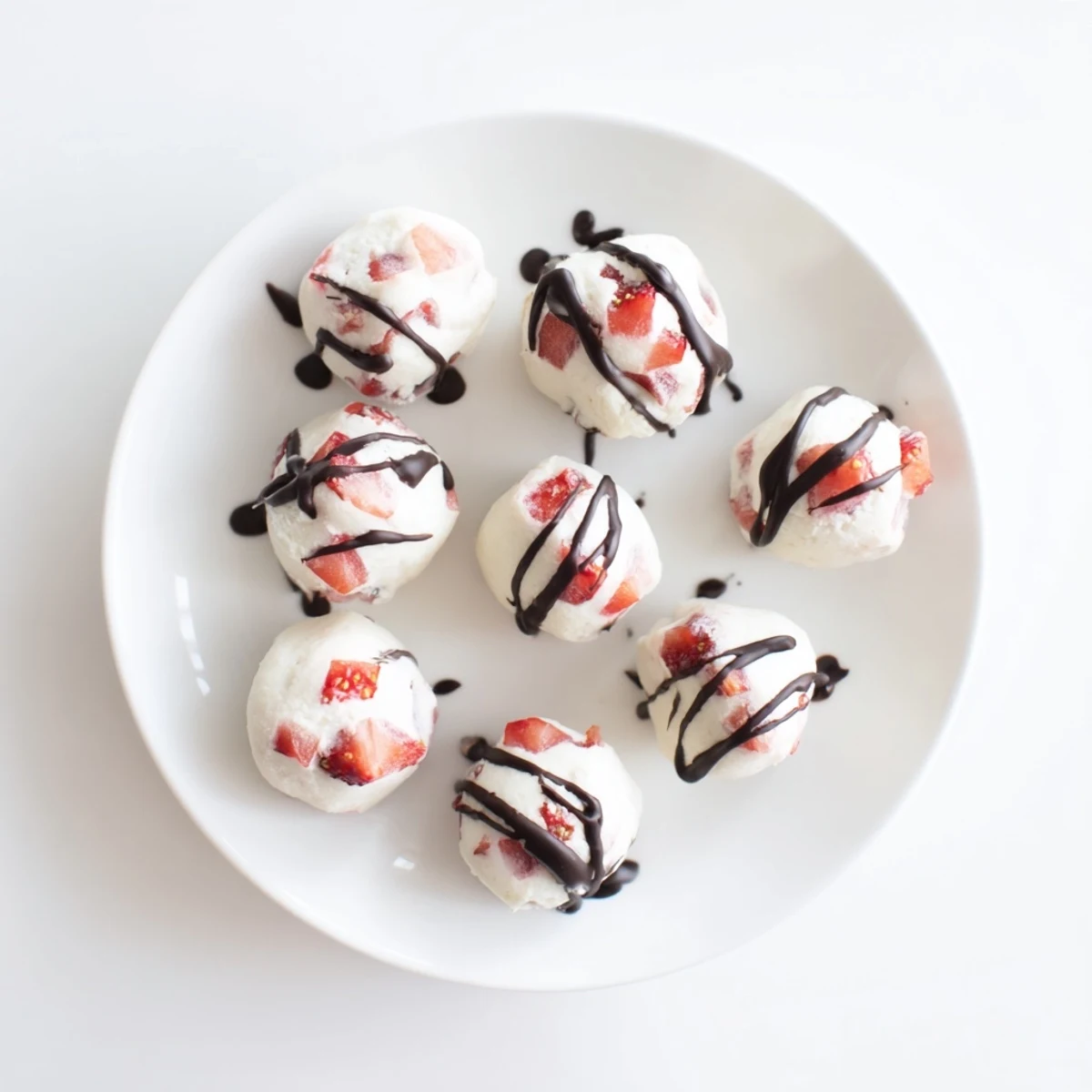 Creamy frozen strawberry high protein yogurt bites drizzled with melted dark chocolate topping