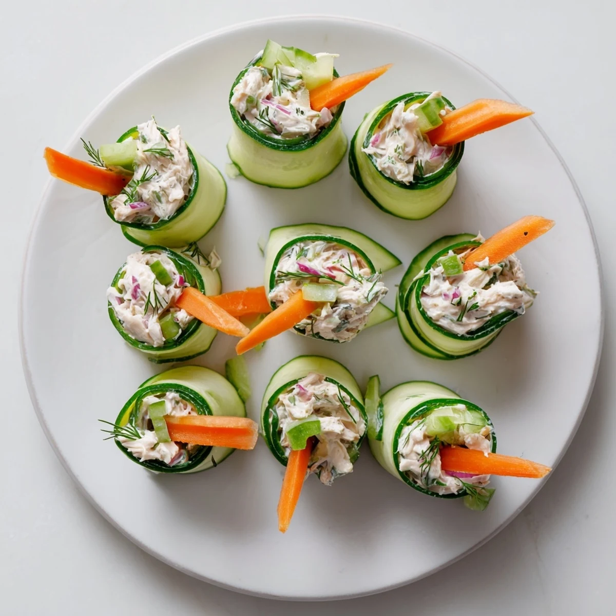 Crisp cucumber ribbons wrap savory chicken salad bites for an easy low carb lunch