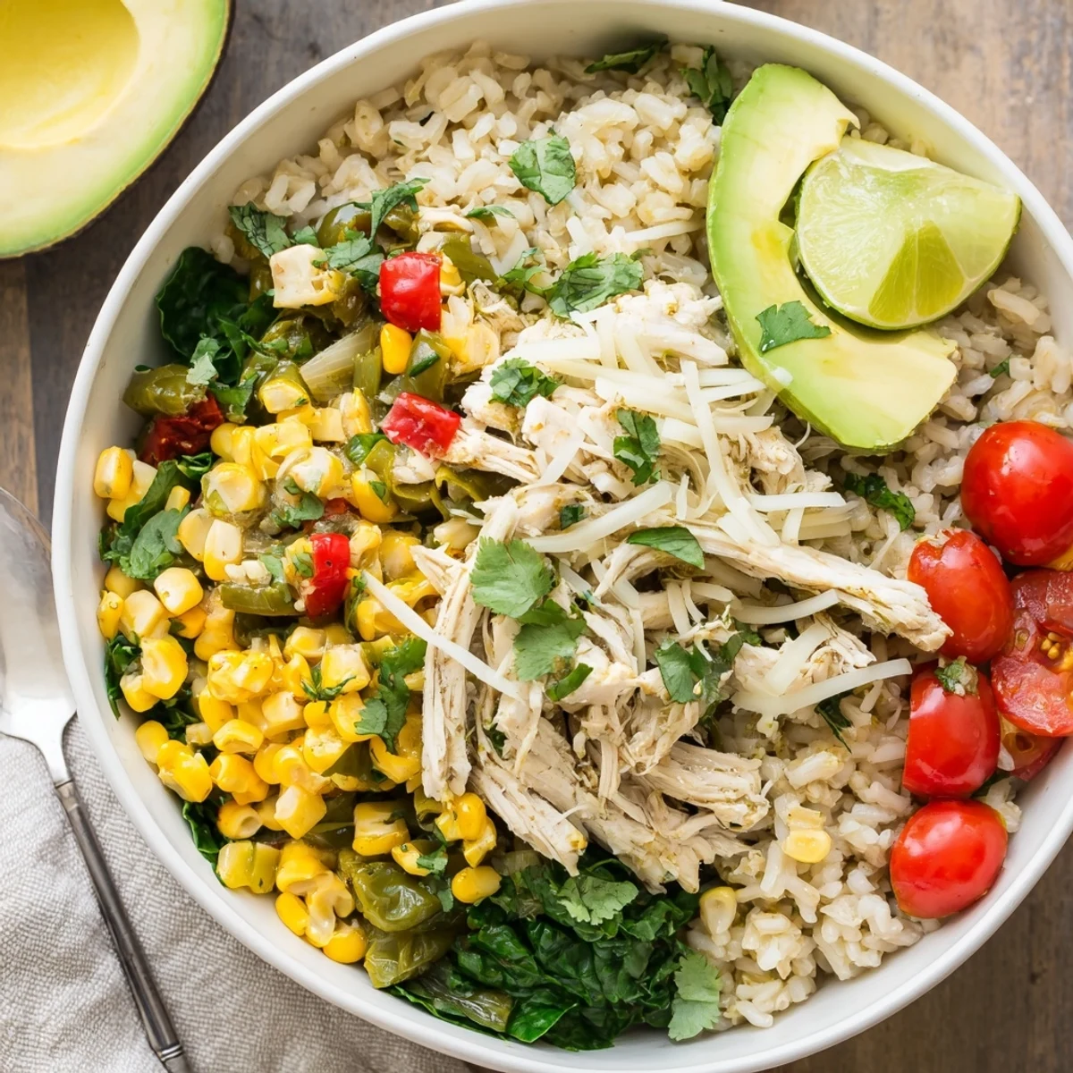 Colorful Southwest spice green chile bowl with juicy chicken, fresh corn and zesty lime wedges