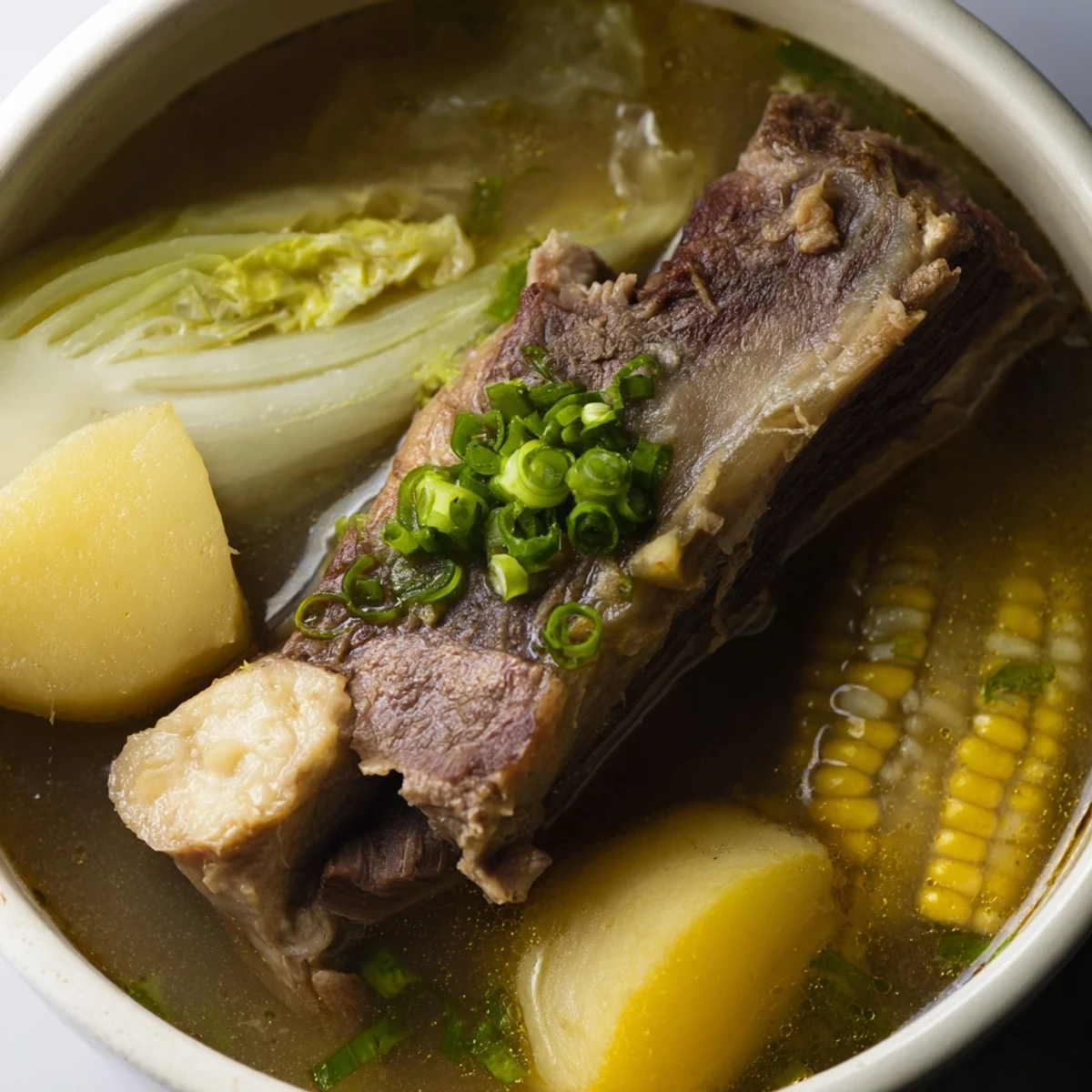 Steaming bowl of Filipino Bulalo with tender beef shank and golden bone marrow