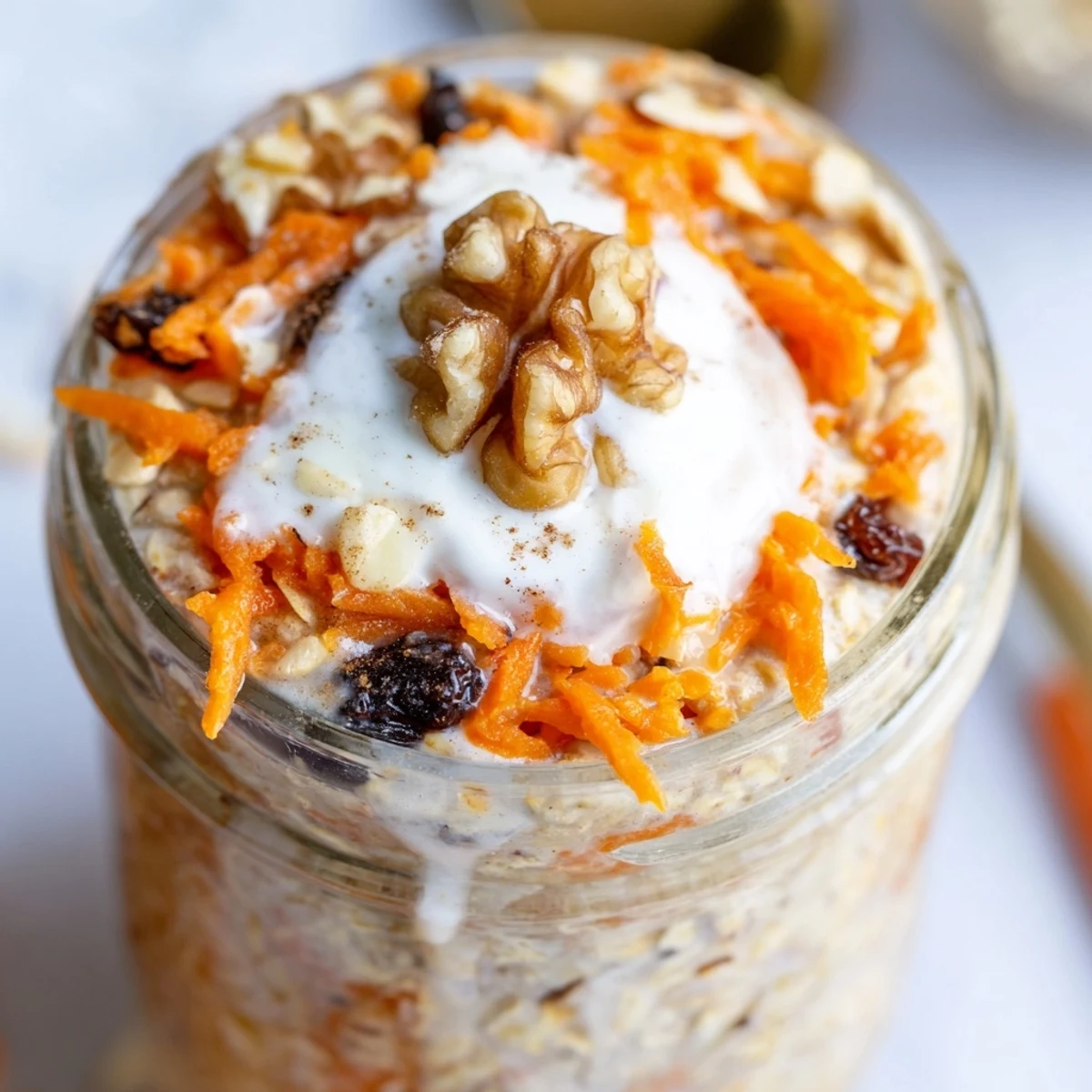 Spiced carrot cake overnight oats in a jar with golden raisins and shredded coconut