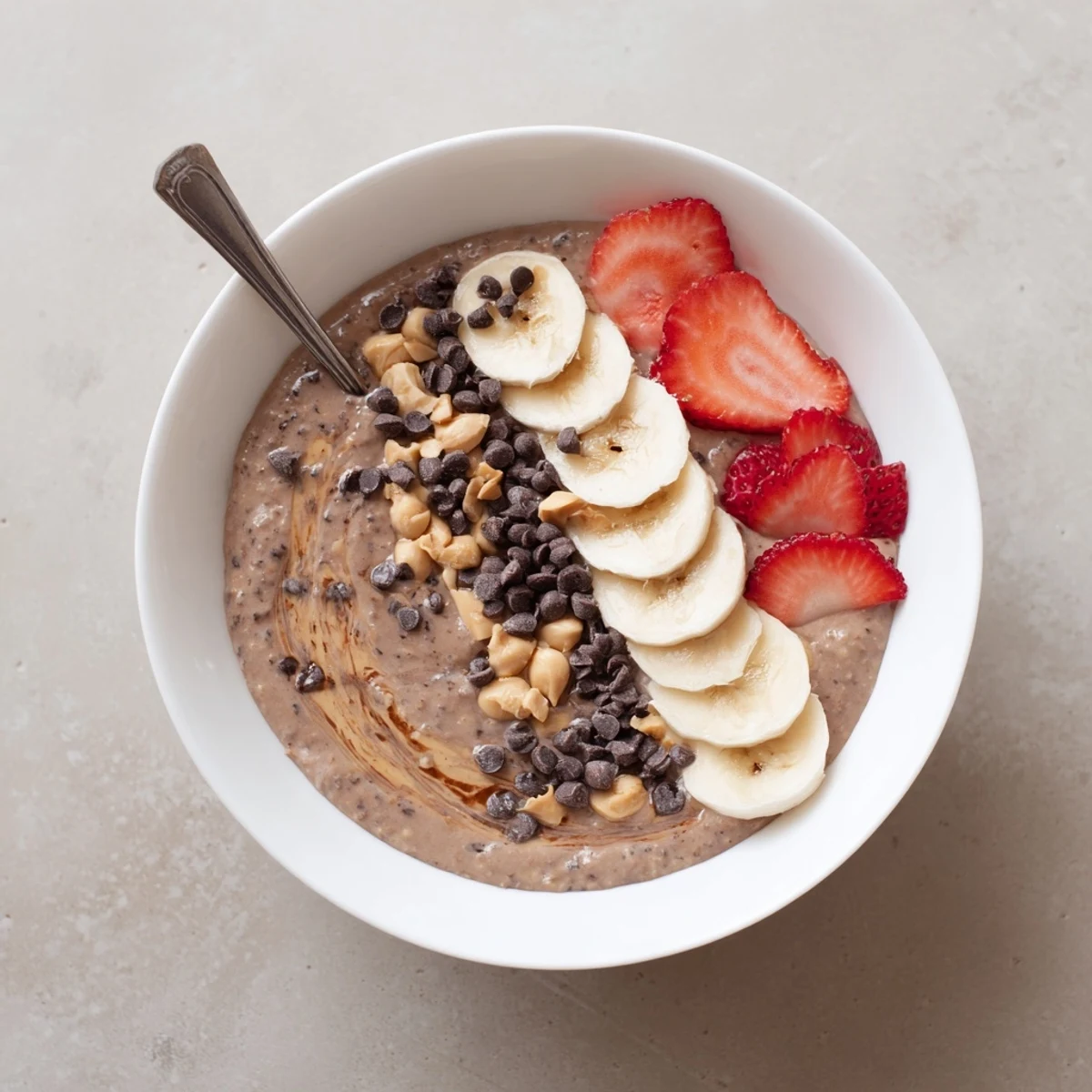 Creamy chocolate peanut butter overnight oats topped with crunchy peanuts and mini chocolate chips