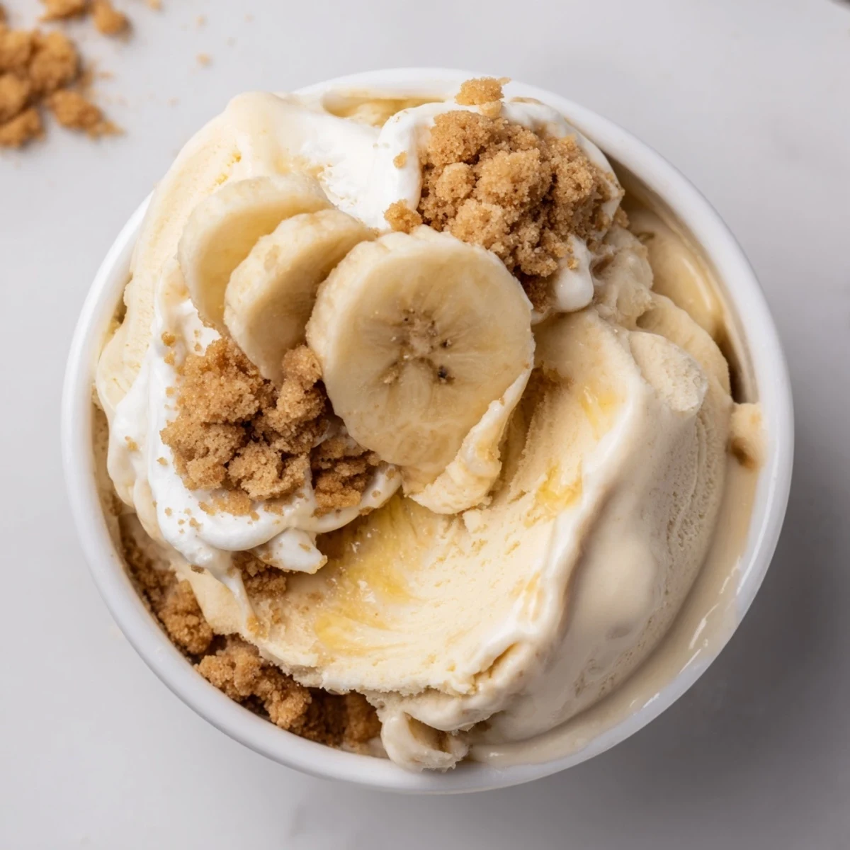 Frozen Ninja Creami Banana Cream Pie Ice Cream scoops garnished with sliced bananas
