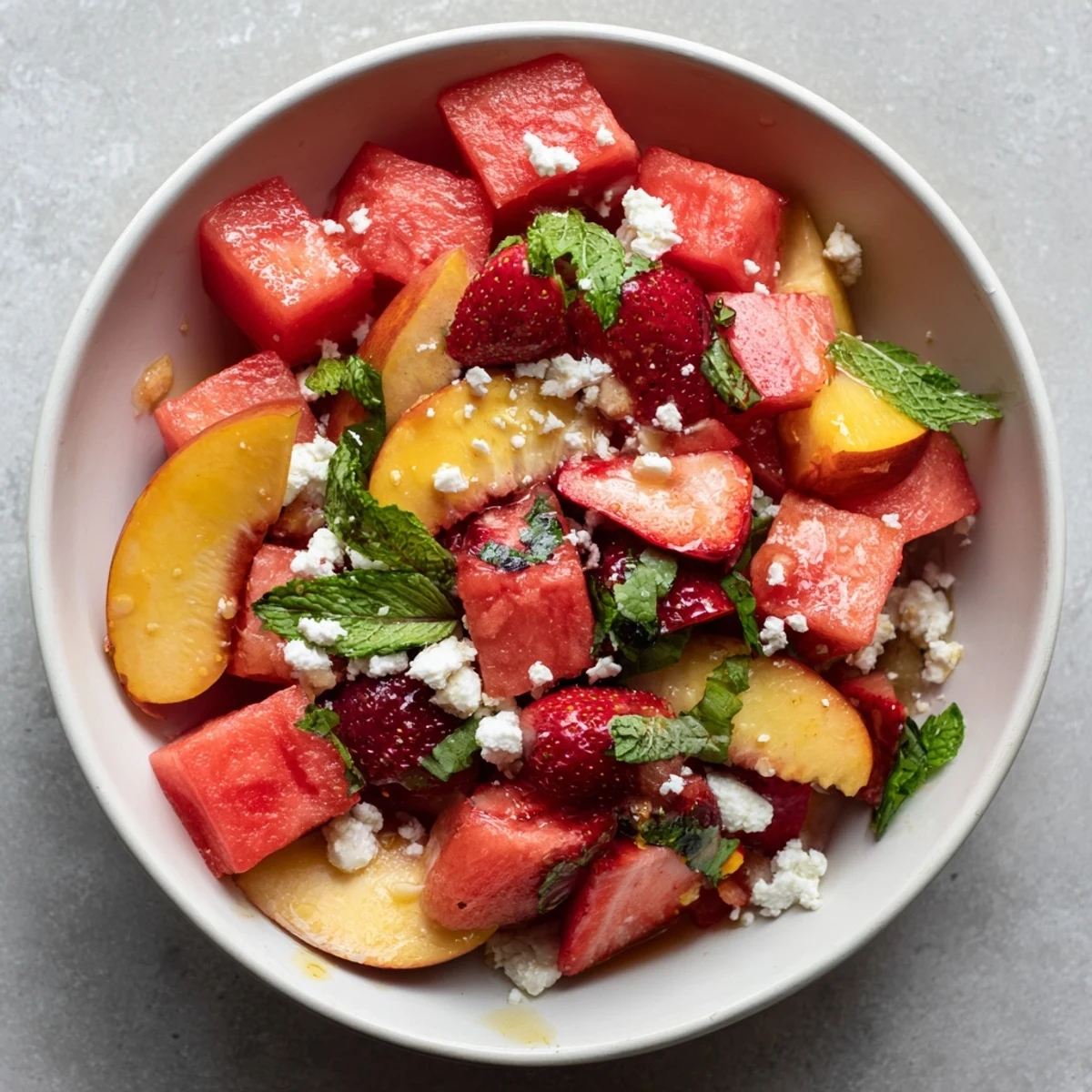 Fresh summer peach watermelon salad featuring juicy fruit cubes topped with crumbled feta cheese