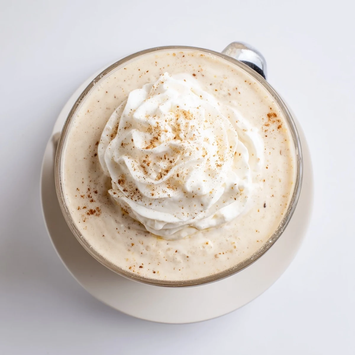 Creamy keto eggnog topped with whipped cream and dusted with nutmeg for a festive holiday drink