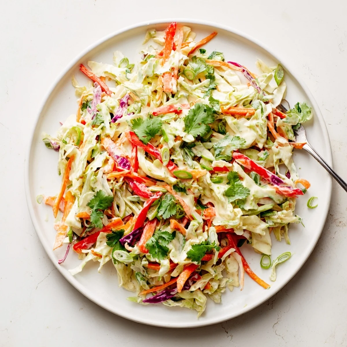 Colorful summer slaw with crisp red and green cabbage tossed in creamy honey-mustard dressing