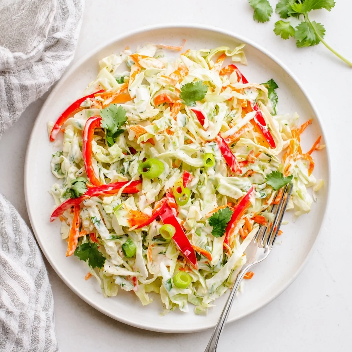 Refreshing summer slaw salad featuring crunchy vegetables and light tangy yogurt-mayo dressing in bowl