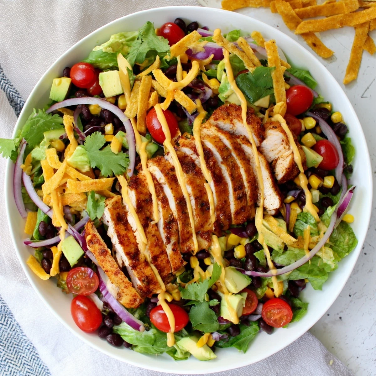 Bowl of healthy Southwestern chicken salad loaded with fresh vegetables grilled chicken breast creamy dressing and cheese