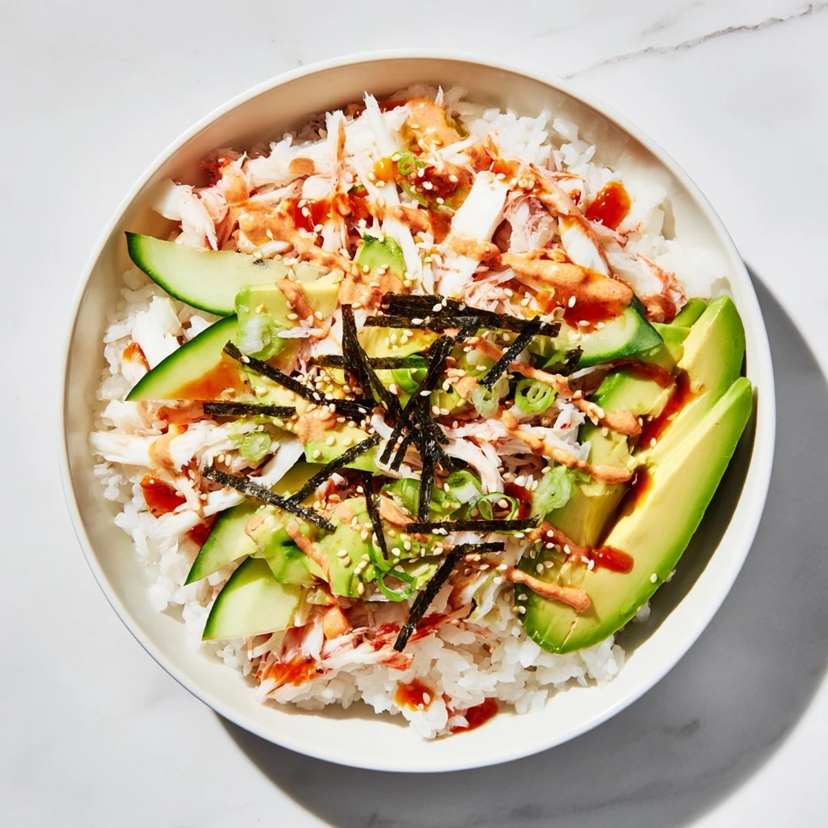 Easy California Roll Sushi Bowl featuring seasoned rice, imitation crab, creamy avocado, and nori strips