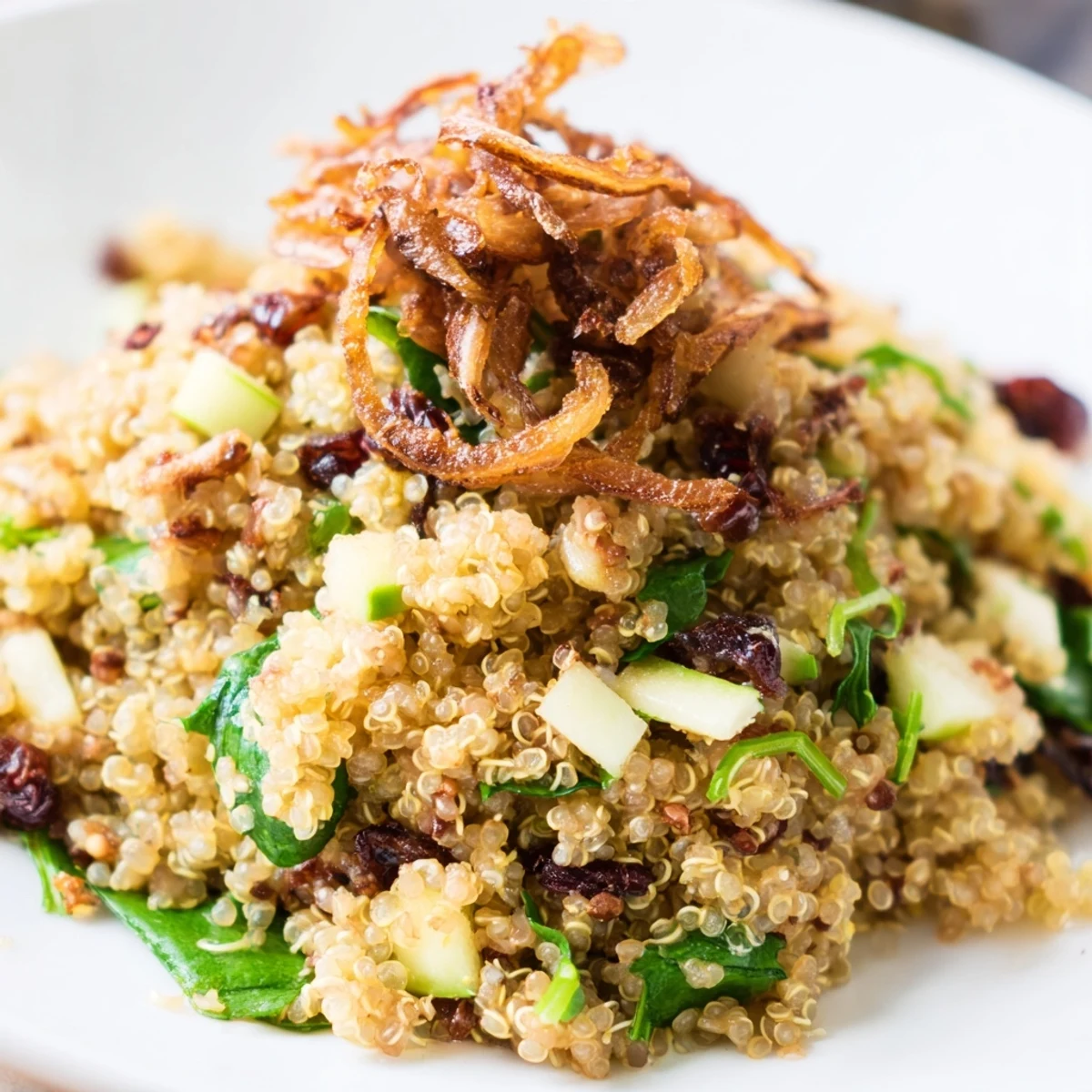 Fluffy quinoa tossed with crisp apples and tangy honey mustard dressing on a white plate