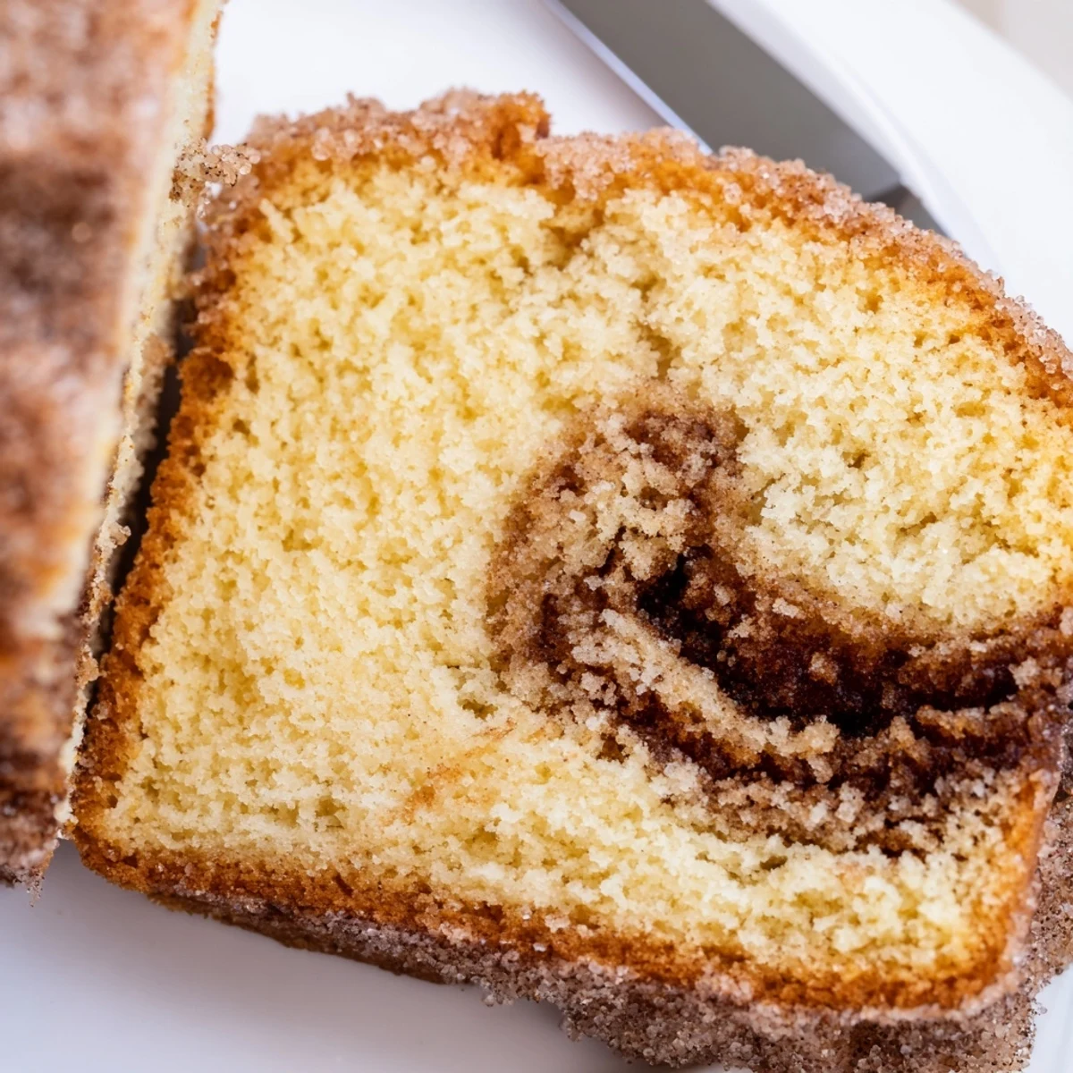 Golden cinnamon donut loaf with a gooey cinnamon sugar swirl served on a plate
