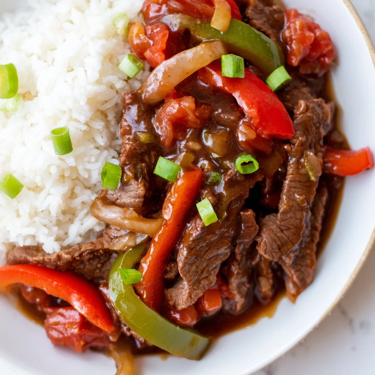 Glossy Slow Cooker Pepper Steak featuring melt-in-your-mouth beef and vibrant red and green pepper strips