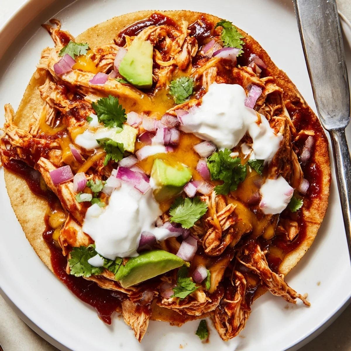 Crispy sweet smoky BBQ chicken tostadas loaded with fresh lettuce, tomato, and creamy avocado slices