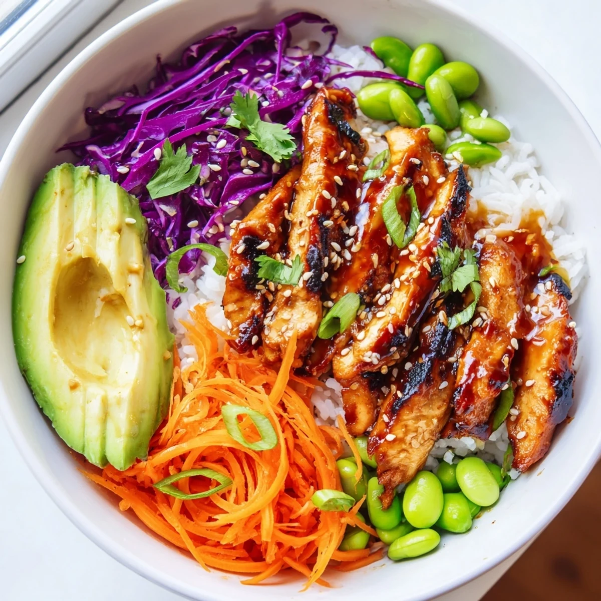 Colorful Asian Inspired Chicken Power Bowl topped with sesame seeds and fresh lime wedges