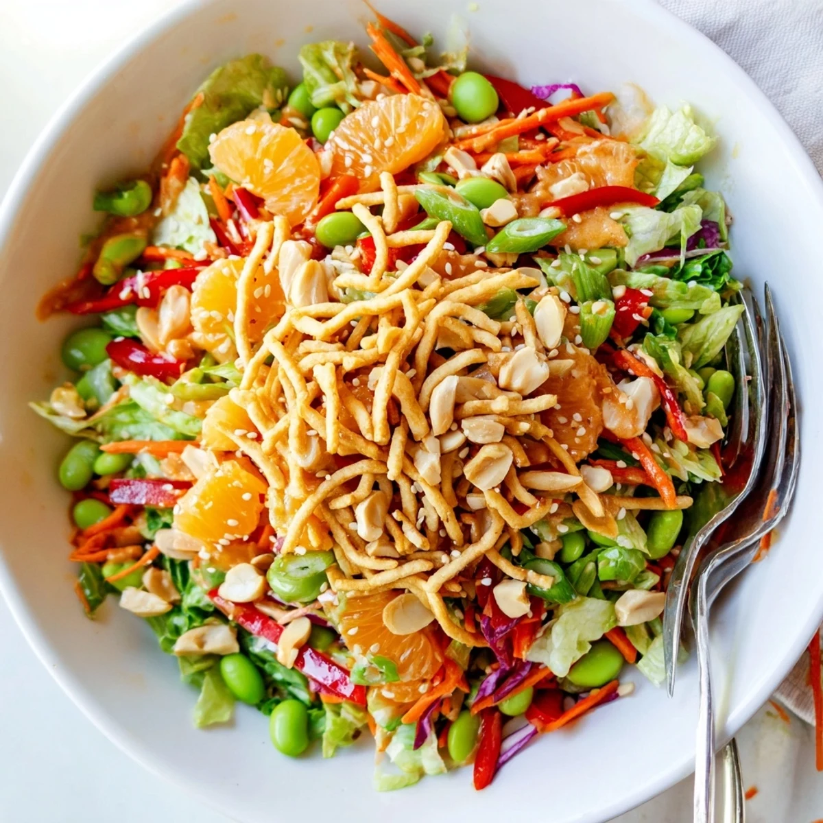Bright Mandarin Sesame Crunch Salad in a wooden bowl glistening with sweet sesame dressing
